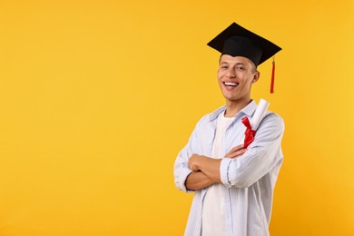 Photo of Happy student with diploma after graduation on orange background. Space for text