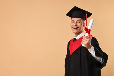 Photo of Happy student with diploma after graduation on beige background. Space for text