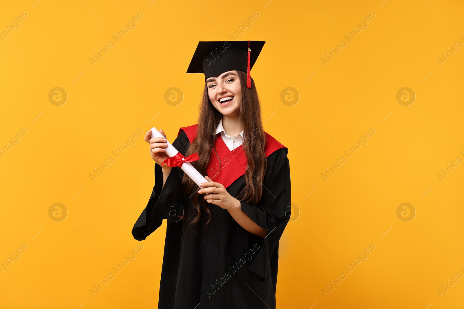 Photo of Happy student with diploma after graduation on orange background