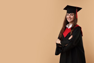 Photo of Happy student with crossed arms after graduation on beige background. Space for text