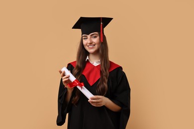 Photo of Happy student with diploma after graduation on beige background