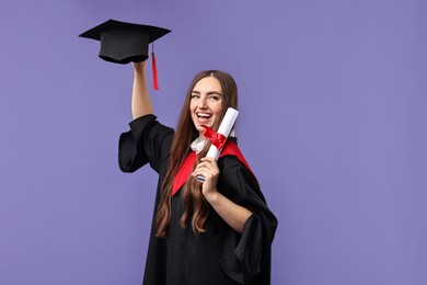 Photo of Happy student with diploma after graduation on violet background