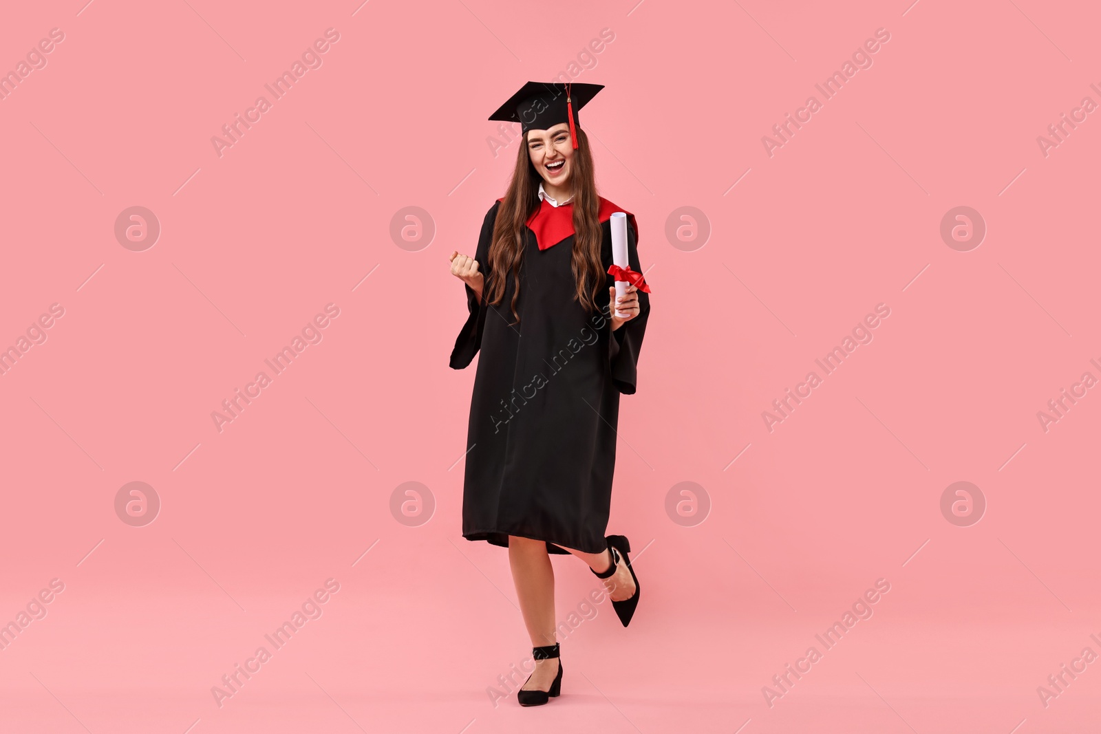 Photo of Happy student with diploma after graduation on pink background