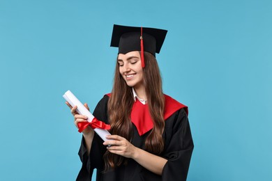 Photo of Happy student with diploma after graduation on light blue background