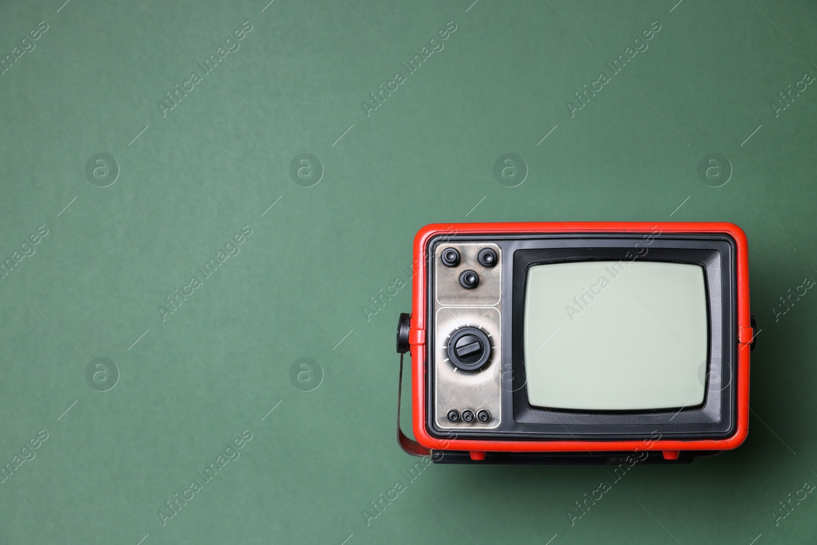 Photo of Retro tv set on green background, top view. Space for text