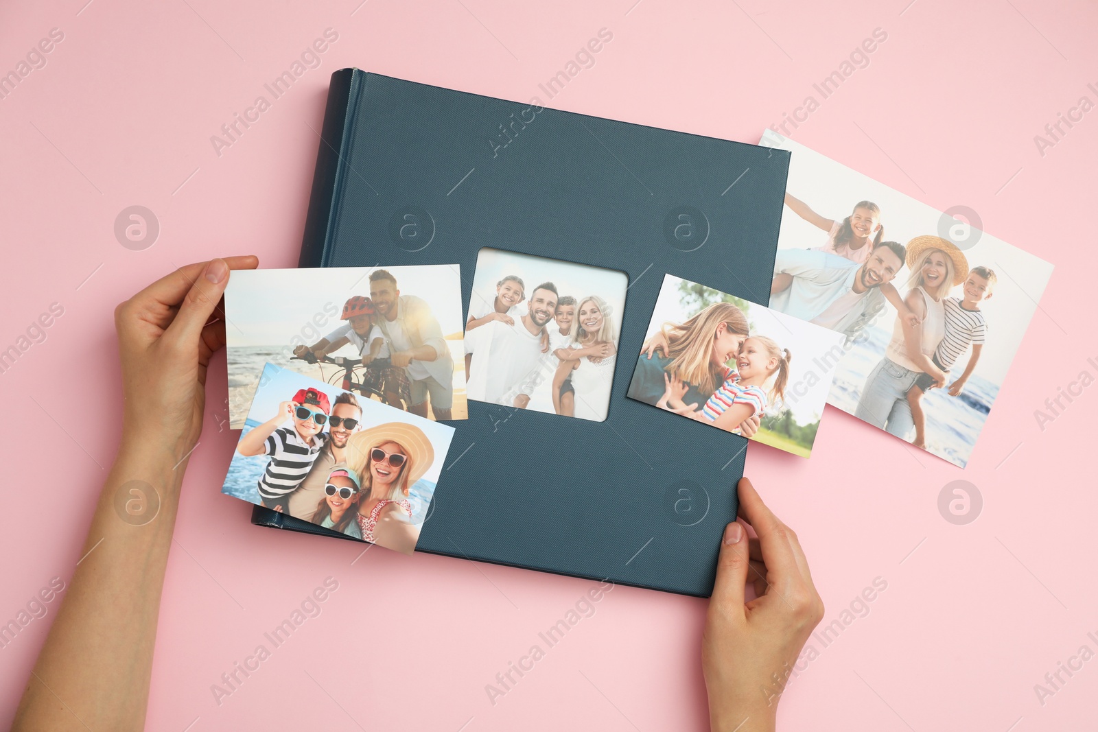 Photo of Woman with photo album and different photos on pink background, top view