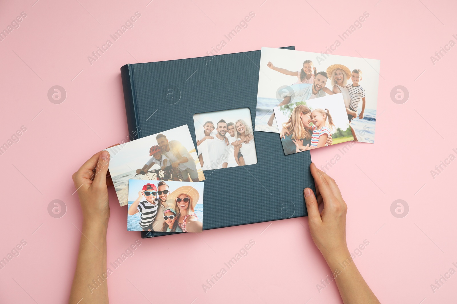 Photo of Woman with photo album and different photos on pink background, top view