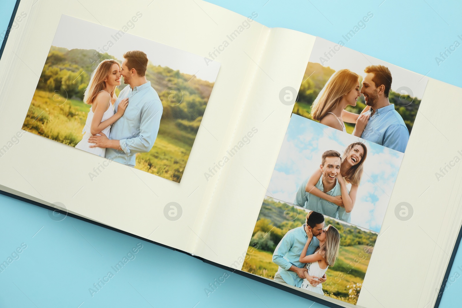 Photo of Open photo album with different photos on light blue background, top view