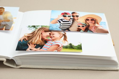 Photo of Open photo album with different photos on beige background, closeup