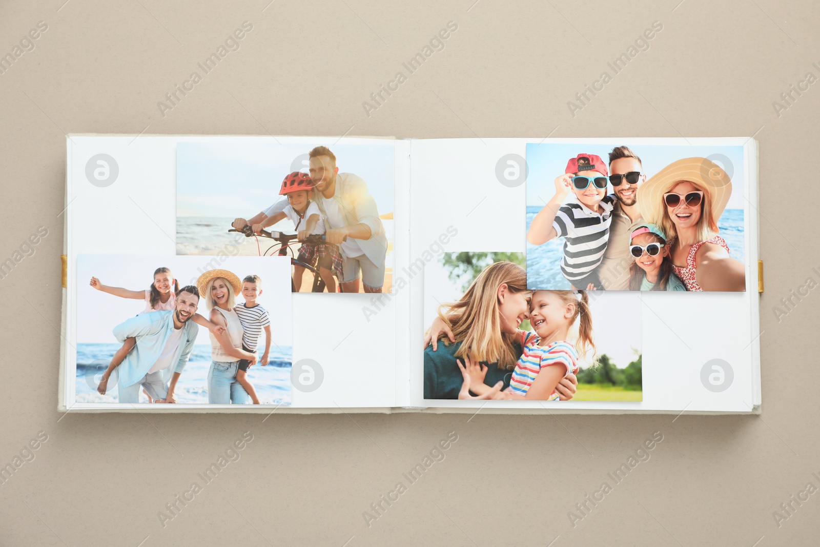 Photo of Open photo album with different photos on beige background, top view