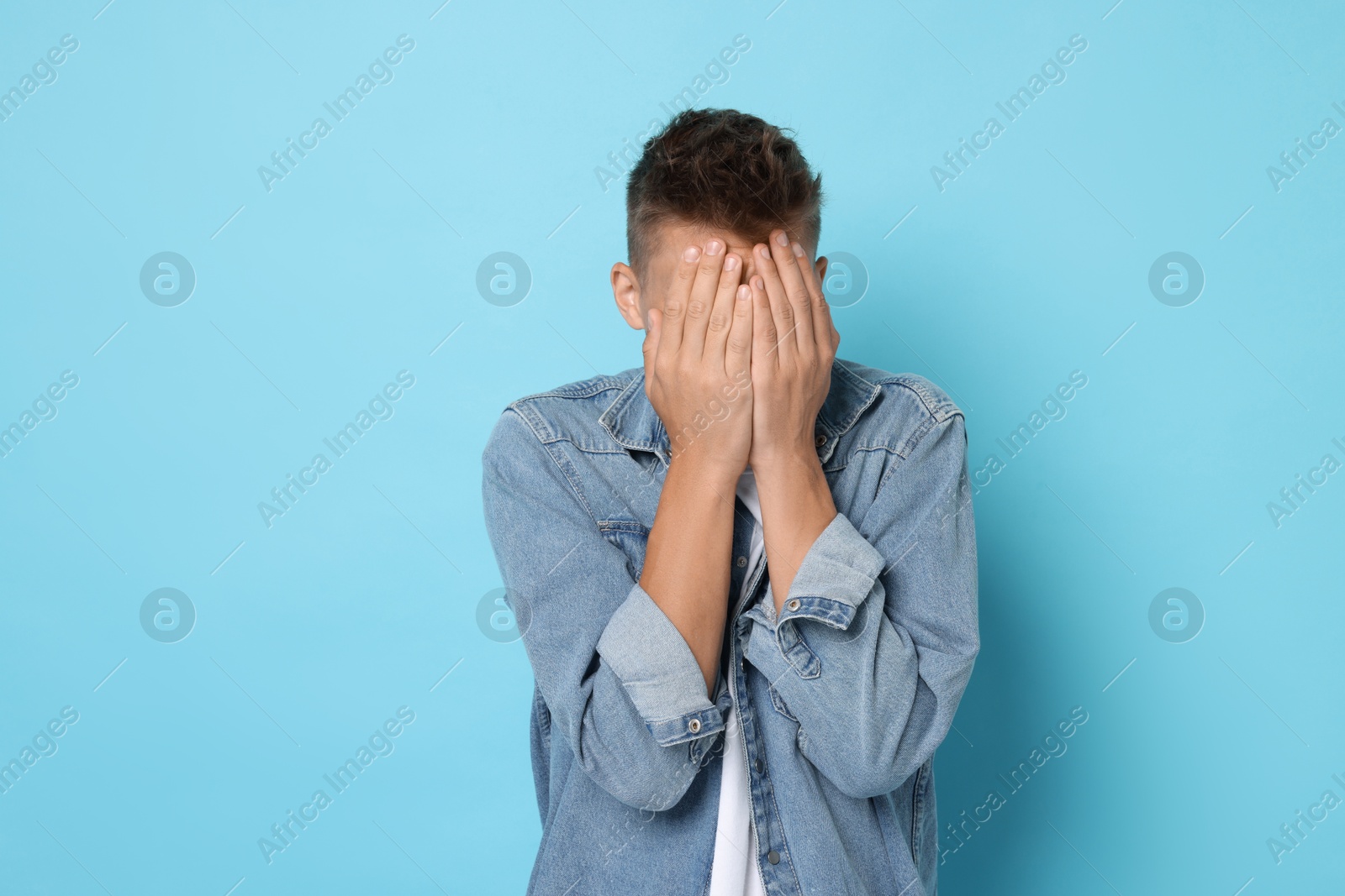 Photo of Portrait of scared young man on light blue background