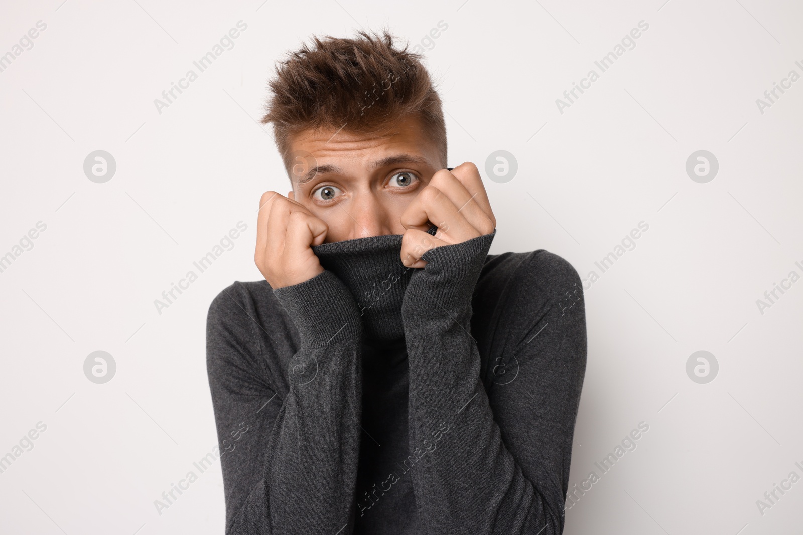 Photo of Portrait of scared young man on light background