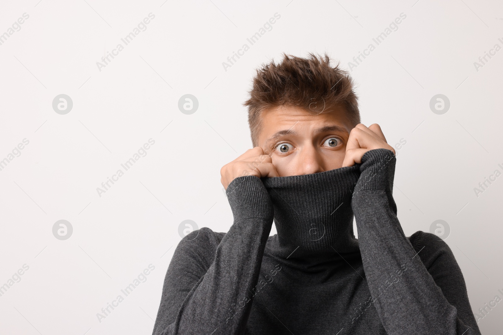 Photo of Portrait of scared young man on light background