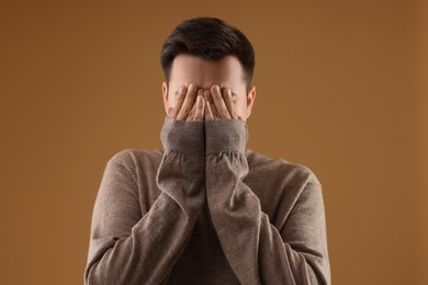 Photo of Portrait of scared young man on brown background