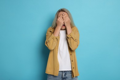 Photo of Portrait of scared woman on light blue background