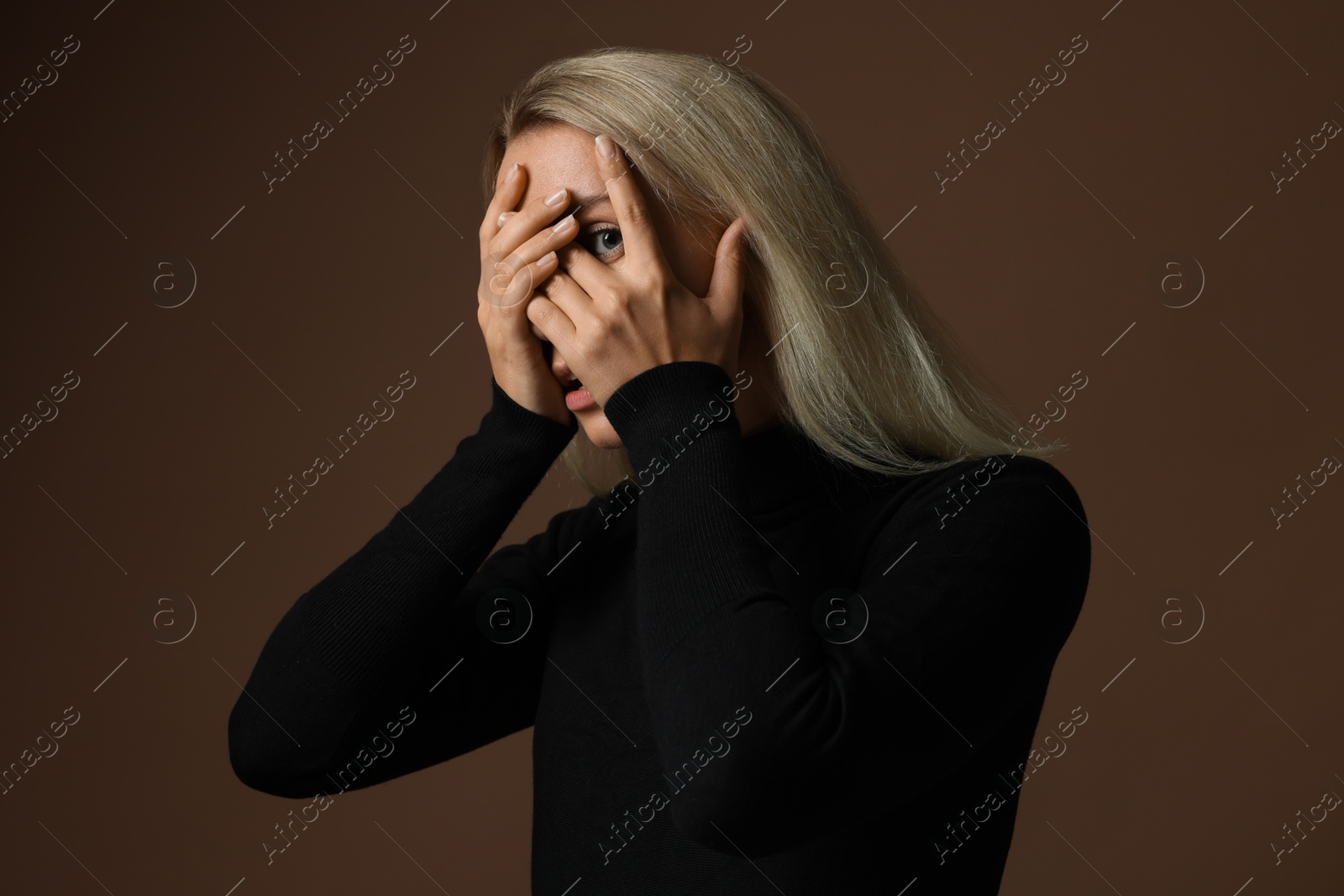 Photo of Portrait of scared woman on brown background