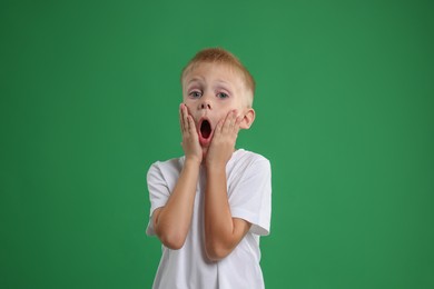 Photo of Portrait of scared little boy on green background