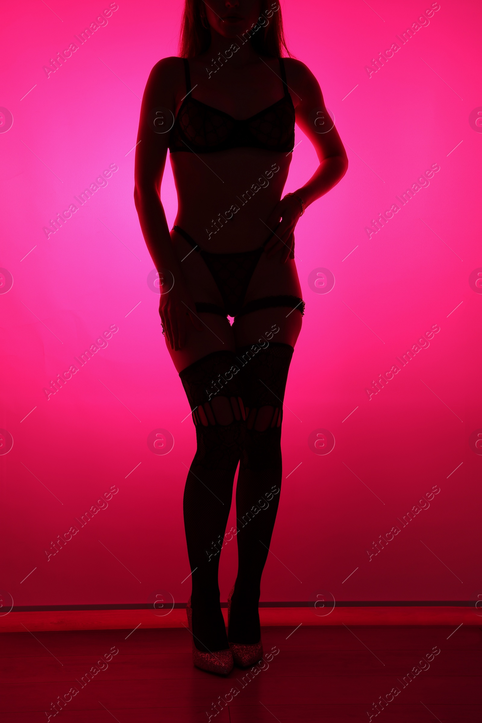 Photo of Prostitution. Woman in underwear indoors in neon lights, closeup