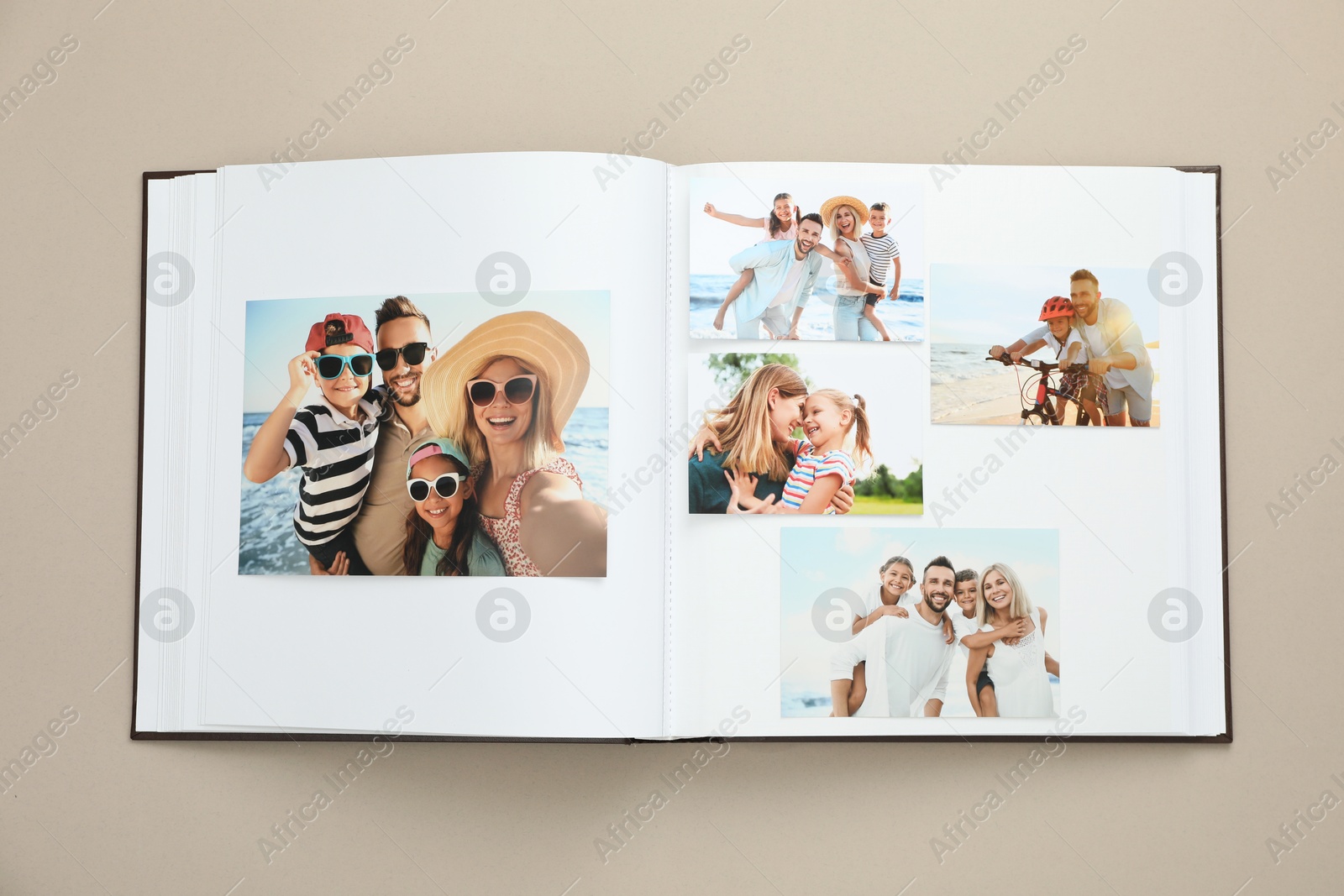 Photo of Open photo album with different photos on beige background, top view