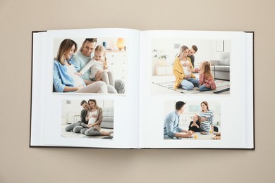 Photo of Open photo album with different photos on beige background, top view