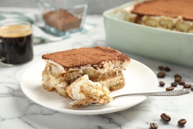 Photo of Piece of tasty tiramisu on white marble table, closeup