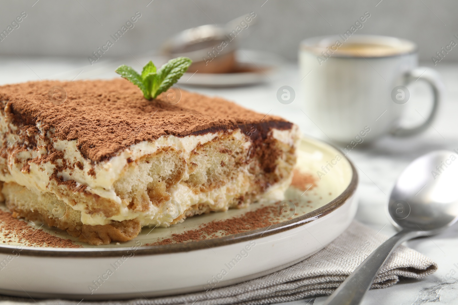 Photo of Piece of tasty tiramisu on white table, closeup