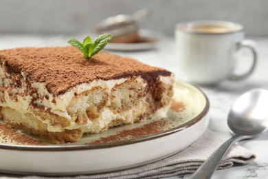 Photo of Piece of tasty tiramisu on white table, closeup