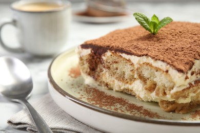 Photo of Piece of tasty tiramisu on white table, closeup