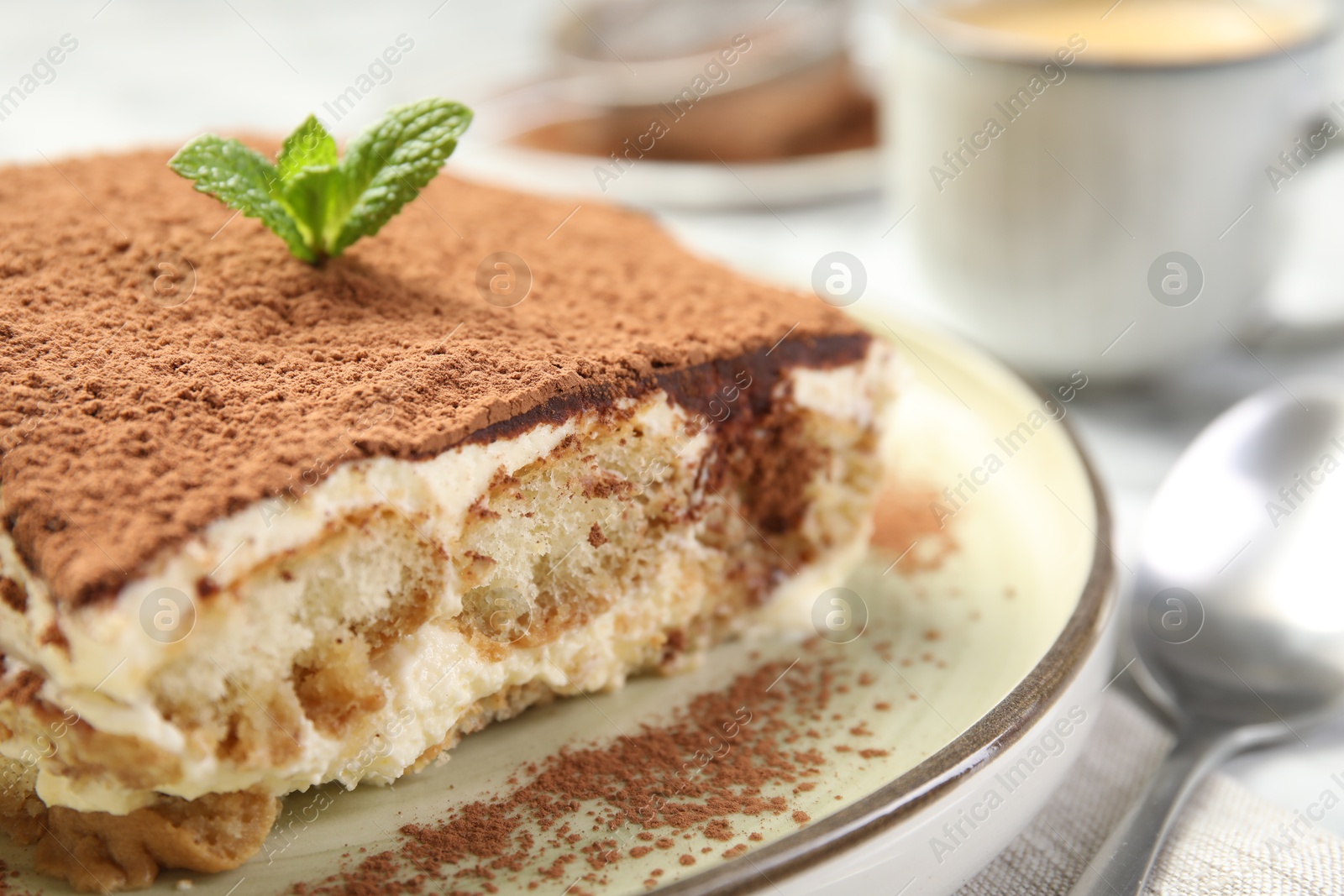 Photo of Piece of tasty tiramisu on white table, closeup