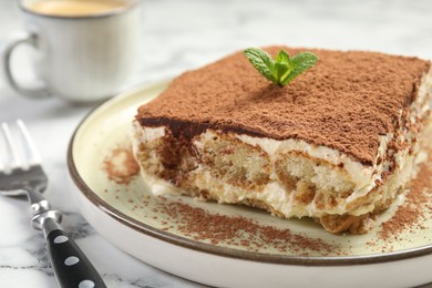 Photo of Piece of tasty tiramisu on white marble table, closeup