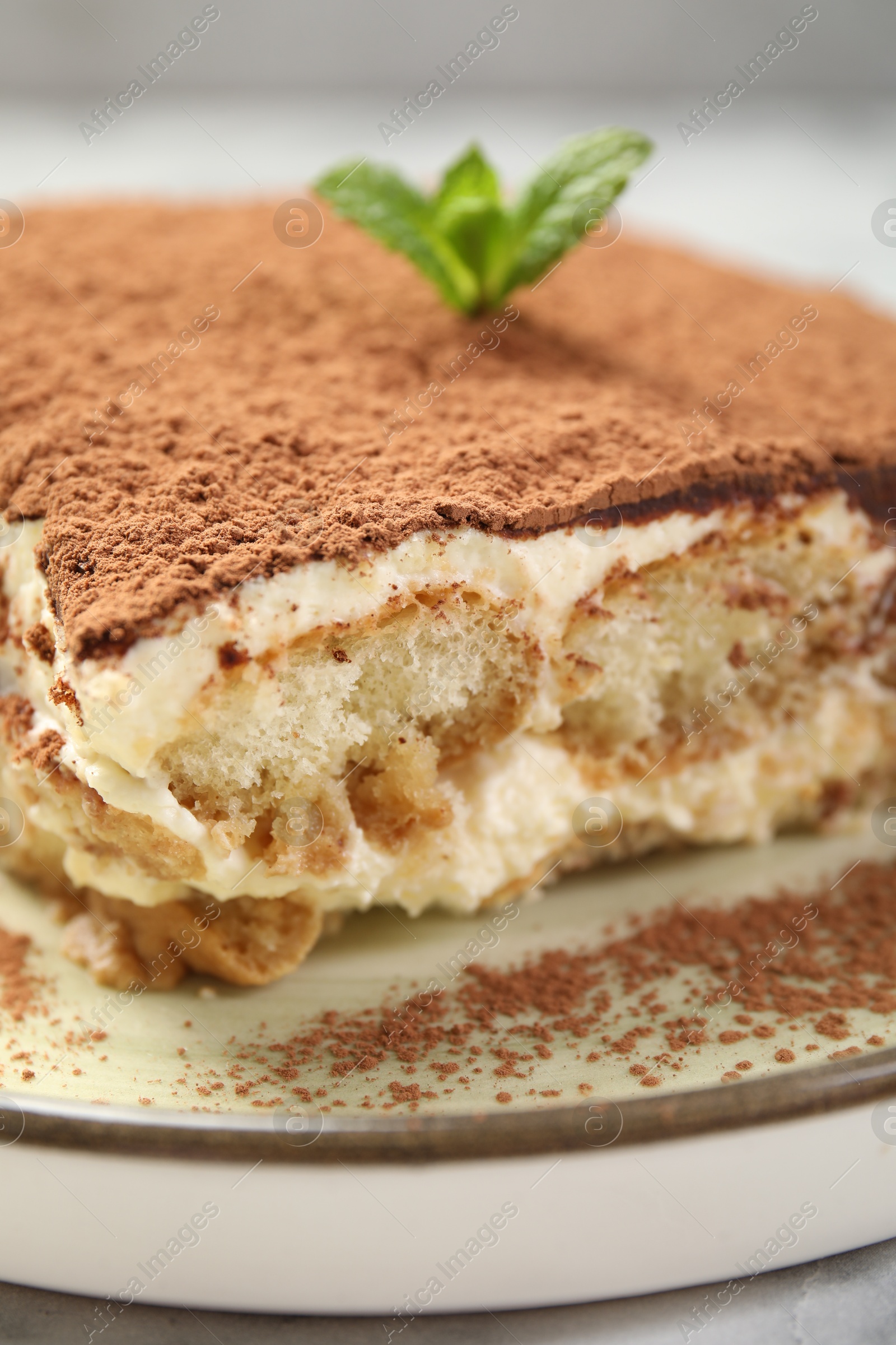 Photo of Piece of tasty tiramisu on white marble table, closeup