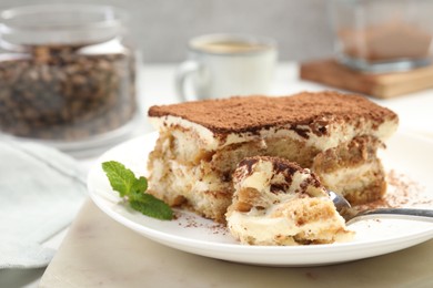 Photo of Piece of tasty tiramisu on table, closeup