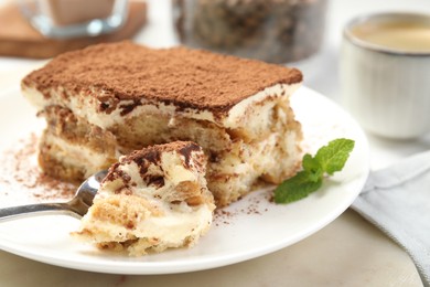 Photo of Piece of tasty tiramisu on table, closeup