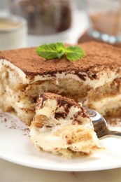 Photo of Piece of tasty tiramisu on table, closeup