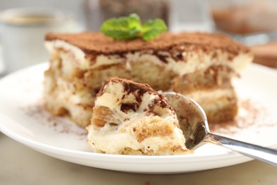 Photo of Piece of tasty tiramisu on table, closeup