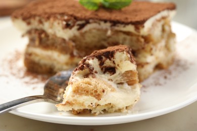 Photo of Piece of tasty tiramisu on table, closeup