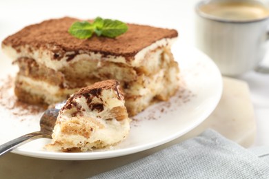 Photo of Piece of tasty tiramisu on table, closeup