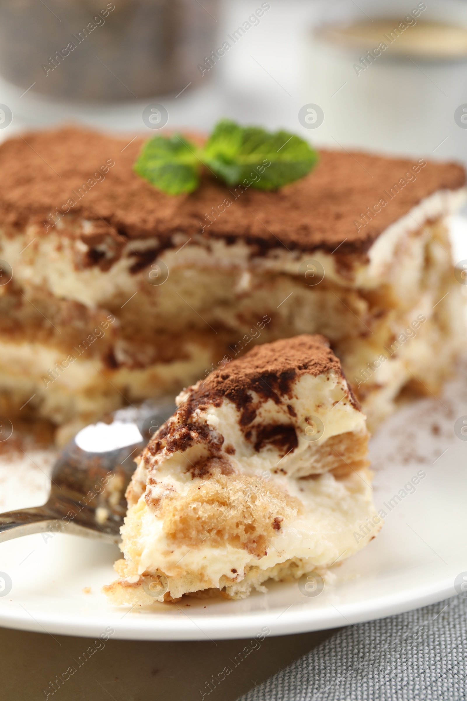 Photo of Piece of tasty tiramisu on table, closeup