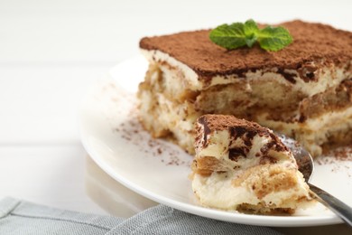 Photo of Piece of tasty tiramisu on table, closeup