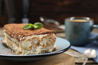 Photo of Piece of tasty tiramisu on wooden table, closeup