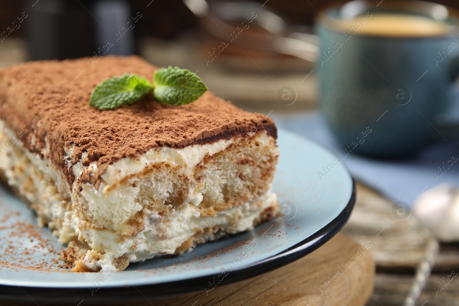 Photo of Piece of tasty tiramisu on wooden table, closeup