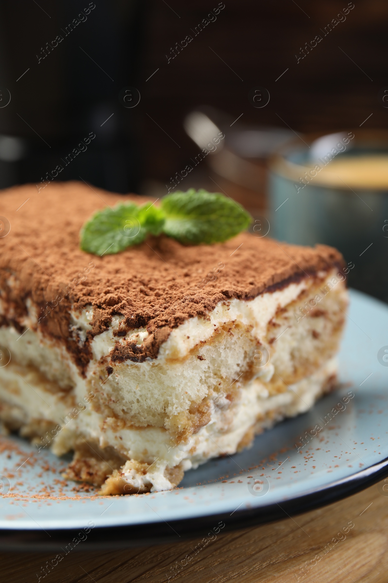 Photo of Piece of tasty tiramisu on wooden table, closeup