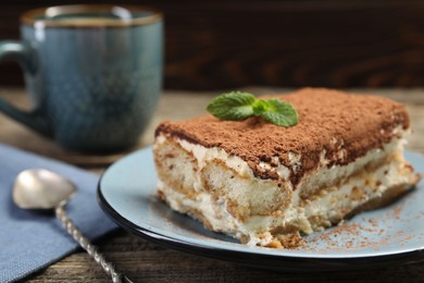 Photo of Piece of tasty tiramisu on wooden table, closeup