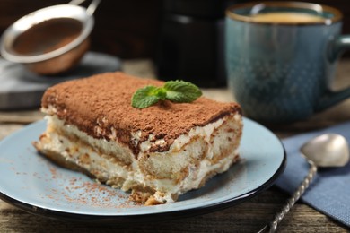 Photo of Piece of tasty tiramisu on wooden table, closeup