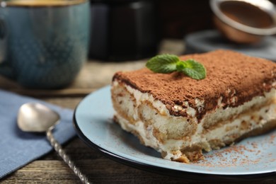 Photo of Piece of tasty tiramisu on wooden table, closeup