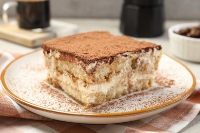 Photo of Piece of tasty tiramisu on table, closeup