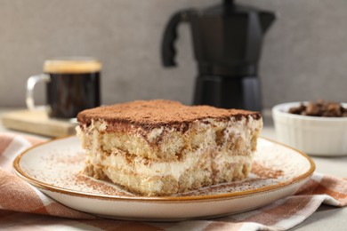 Photo of Piece of tasty tiramisu on table, closeup