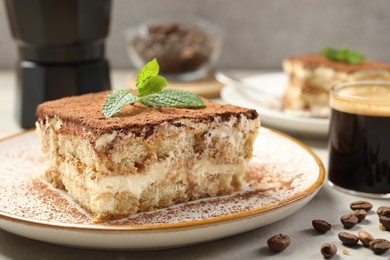 Photo of Piece of tasty tiramisu on beige table, closeup