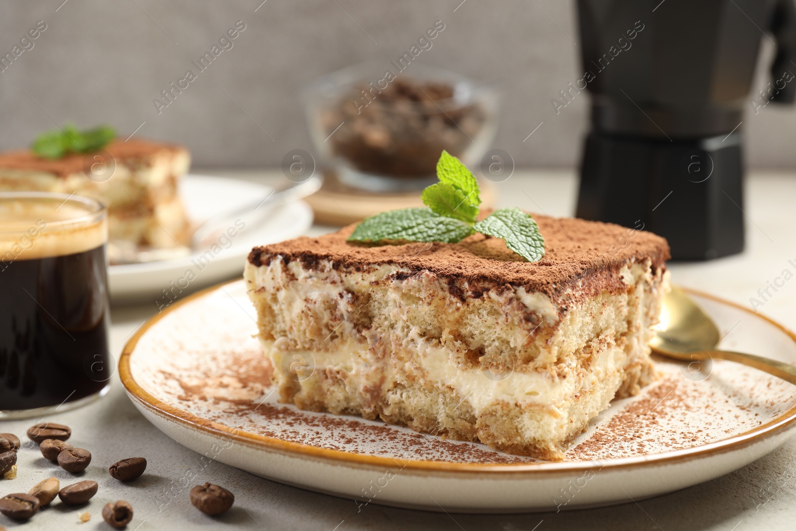 Photo of Piece of tasty tiramisu on beige table, closeup