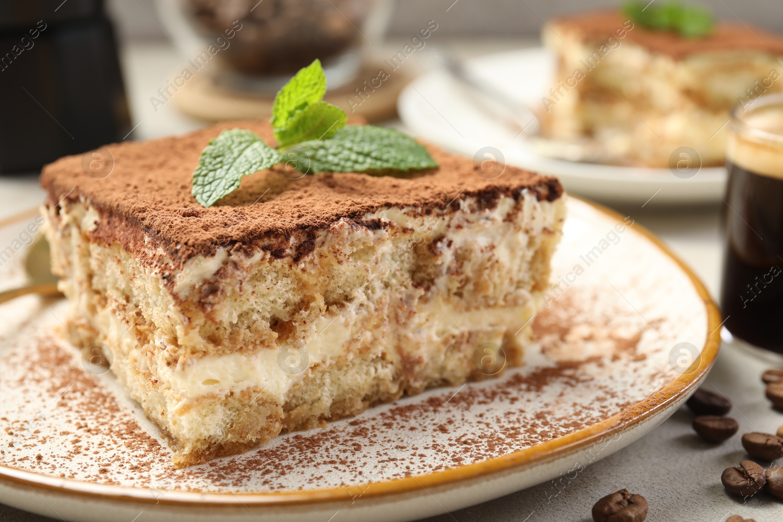 Photo of Piece of tasty tiramisu on beige table, closeup